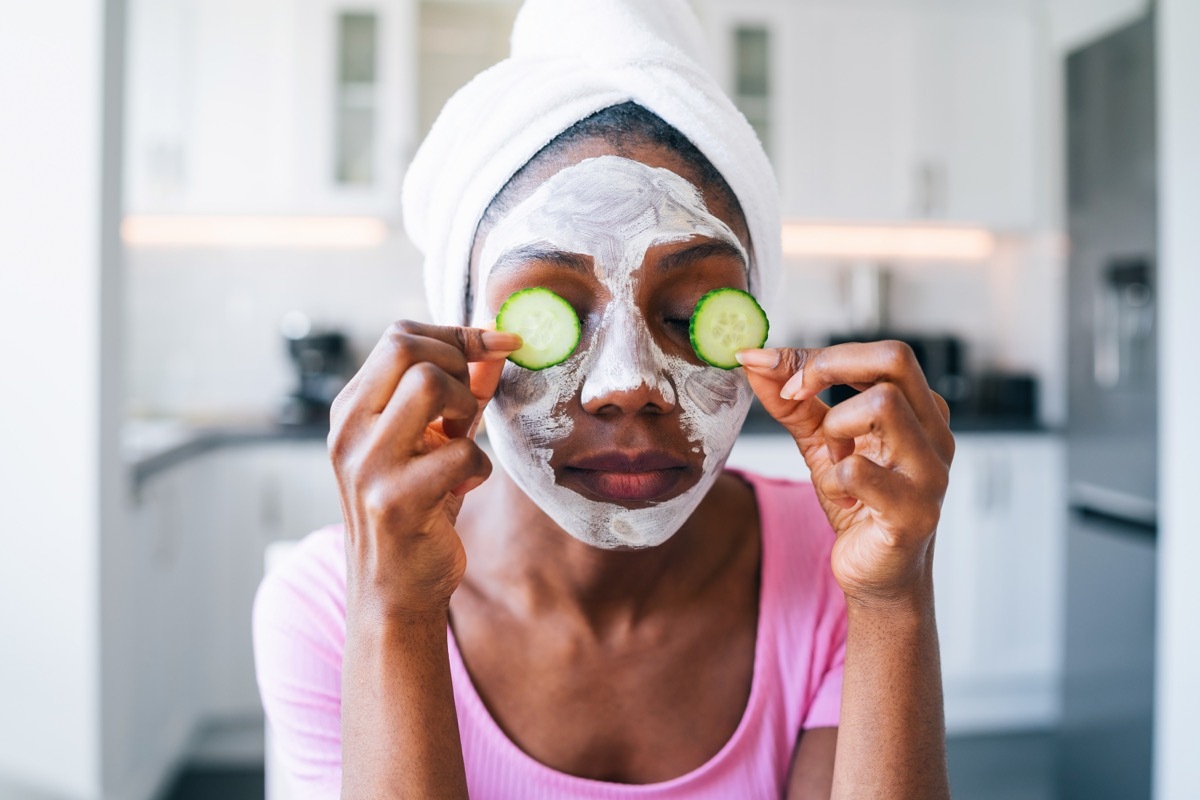 beautiful young black woman with cucumber on eyes