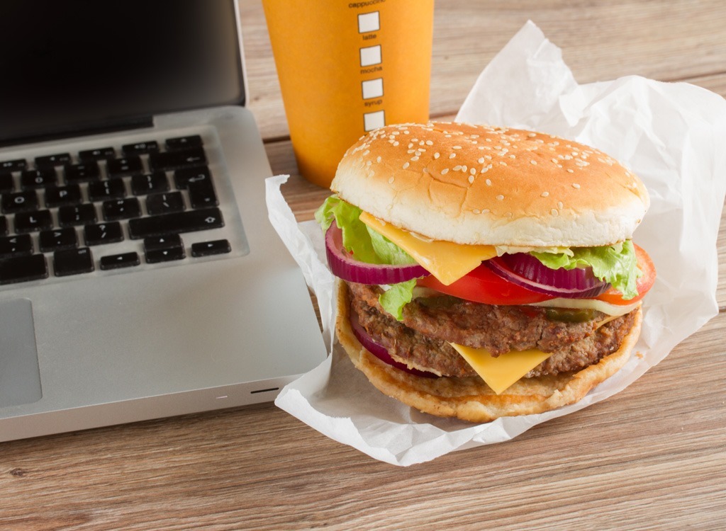 Fast food burger next to laptop