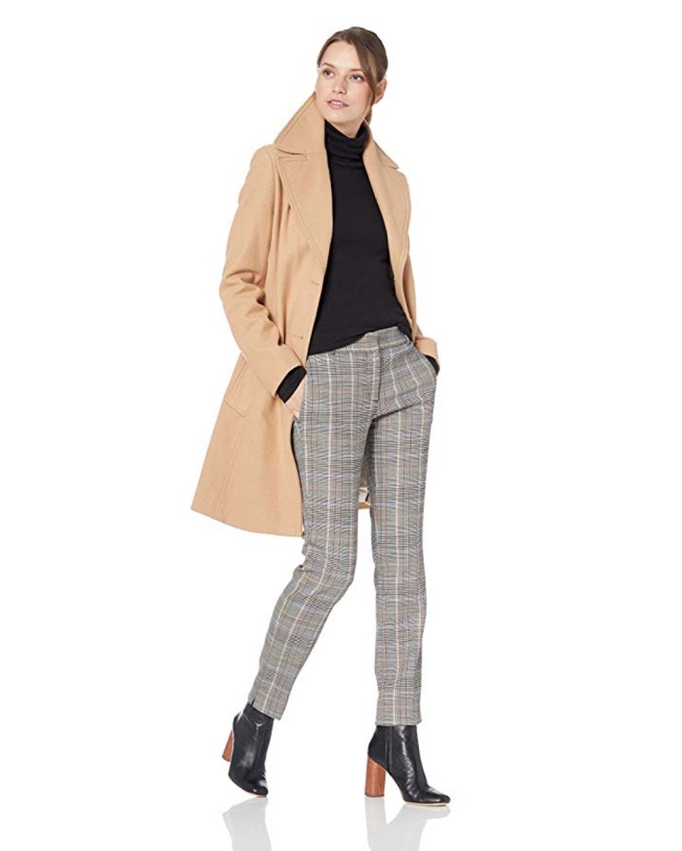 woman wearing tan coat and plaid pants