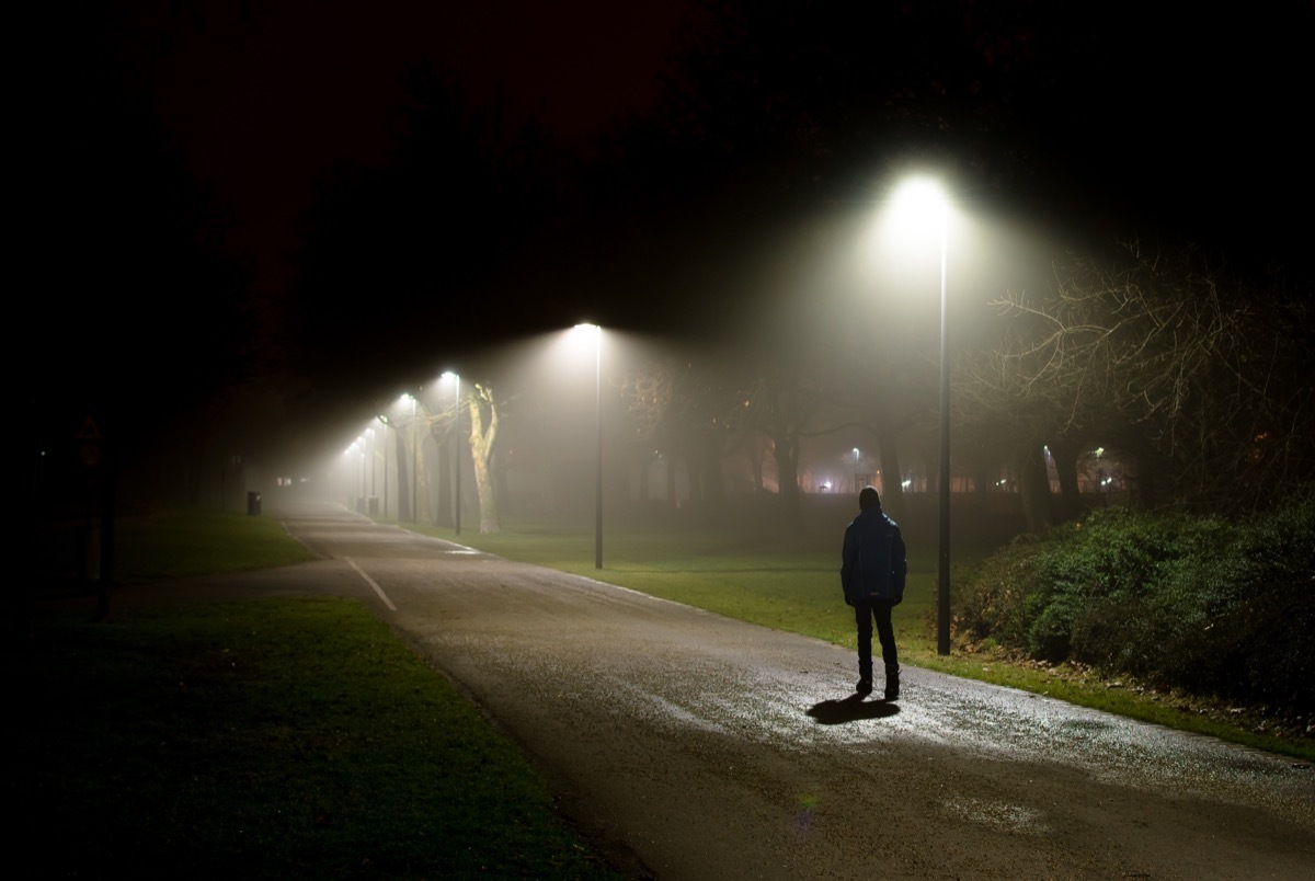 singe person walking on a dark street at night