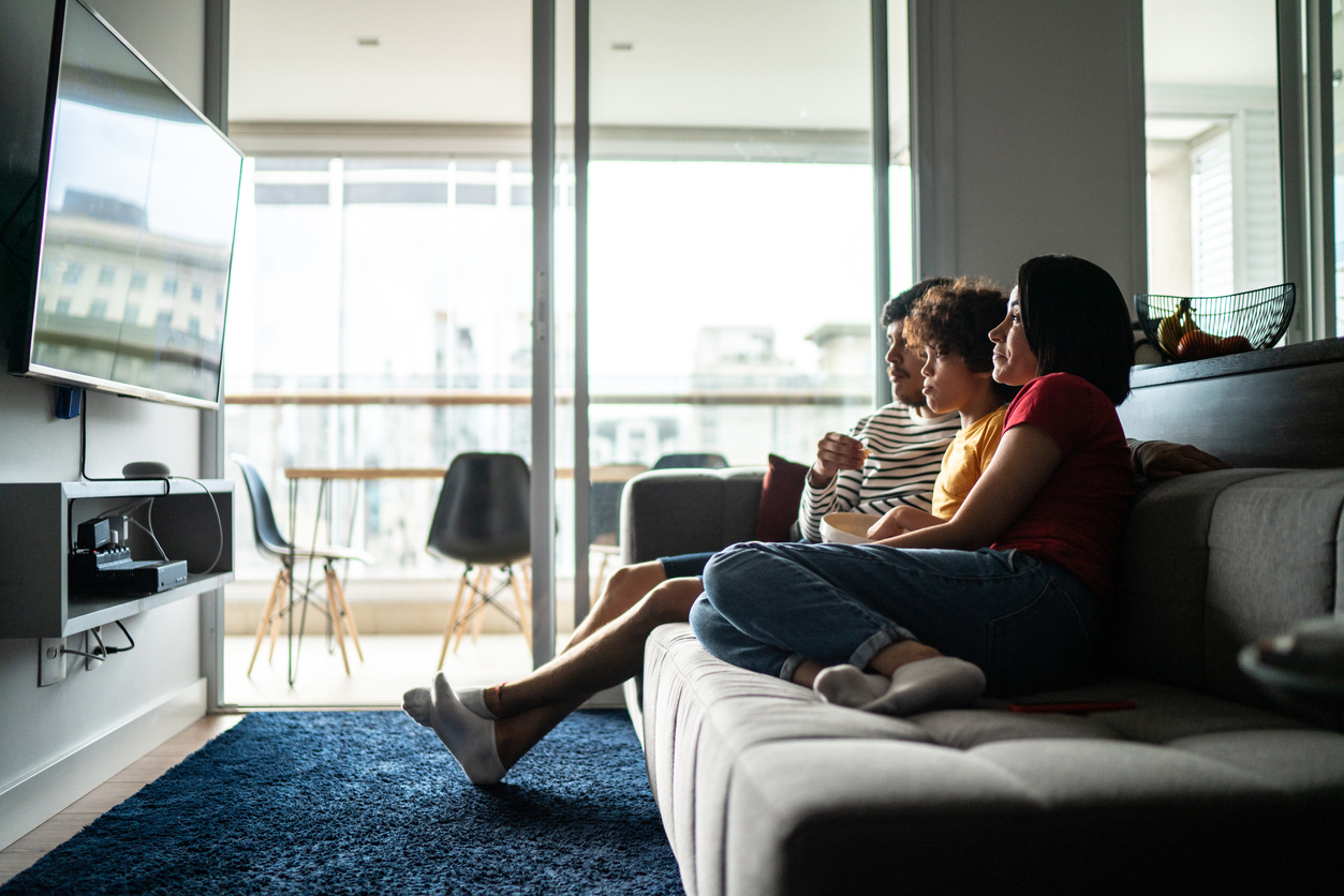 A family sitting on a couch while watching a streaming TV service