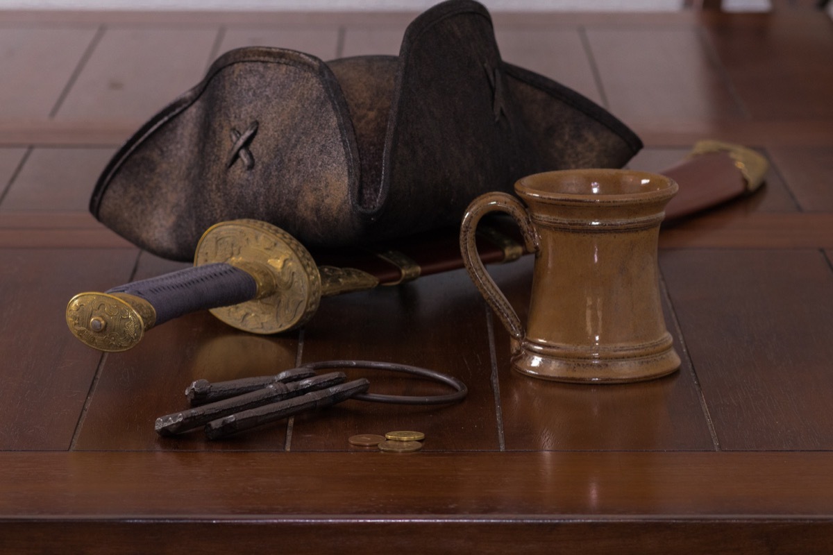 pirate hat and mug on table with sword