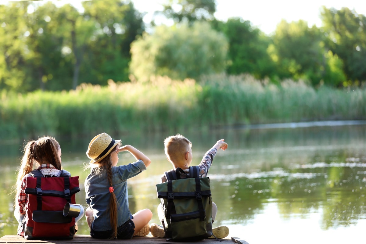 3 kids sitting on pier at camp