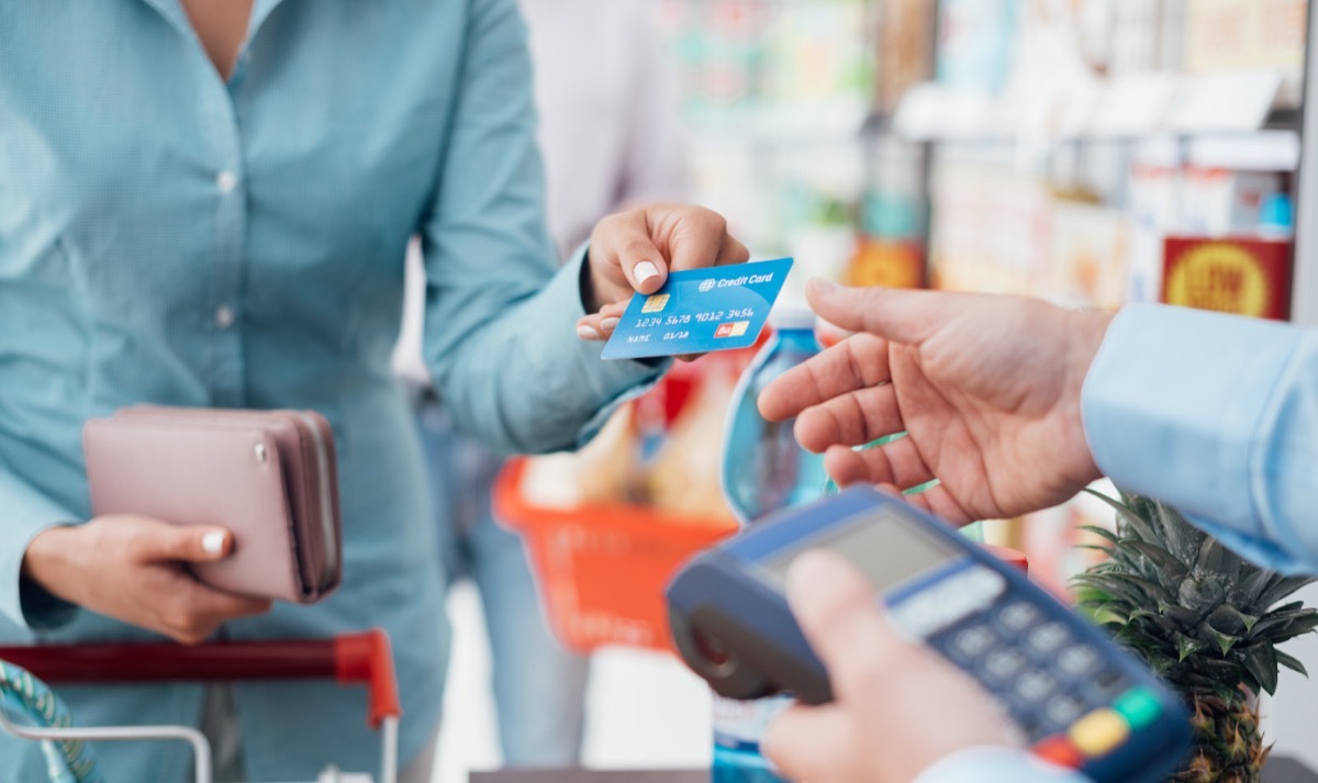 Woman using credit card to pay in store