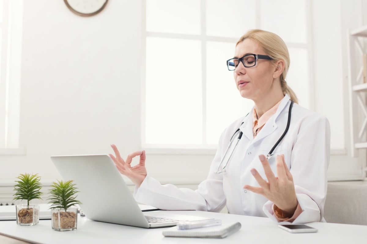 Female doctor meditating at her office