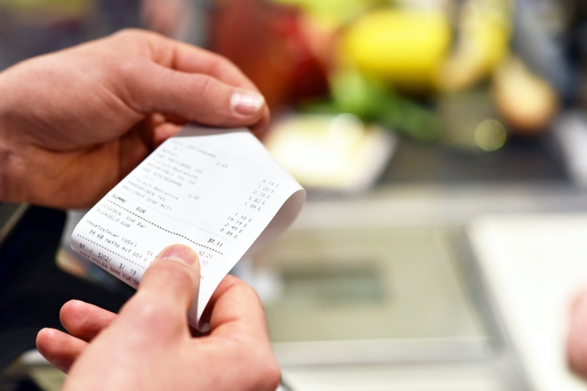 person looking at receipt