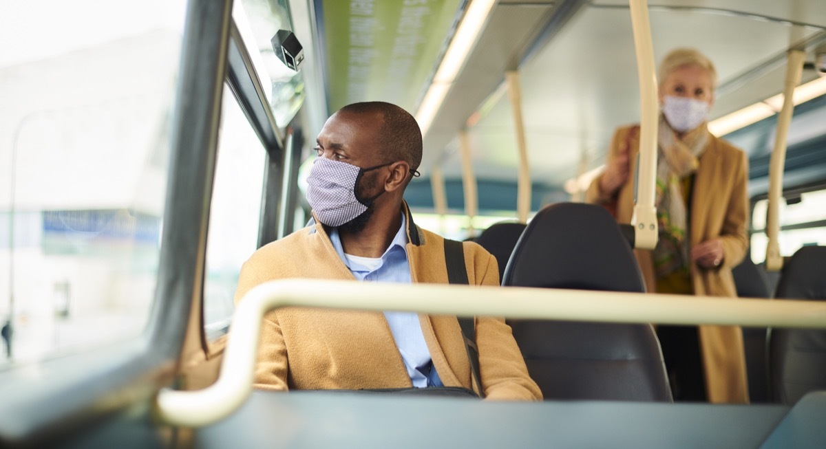 young man wearing mask on bus