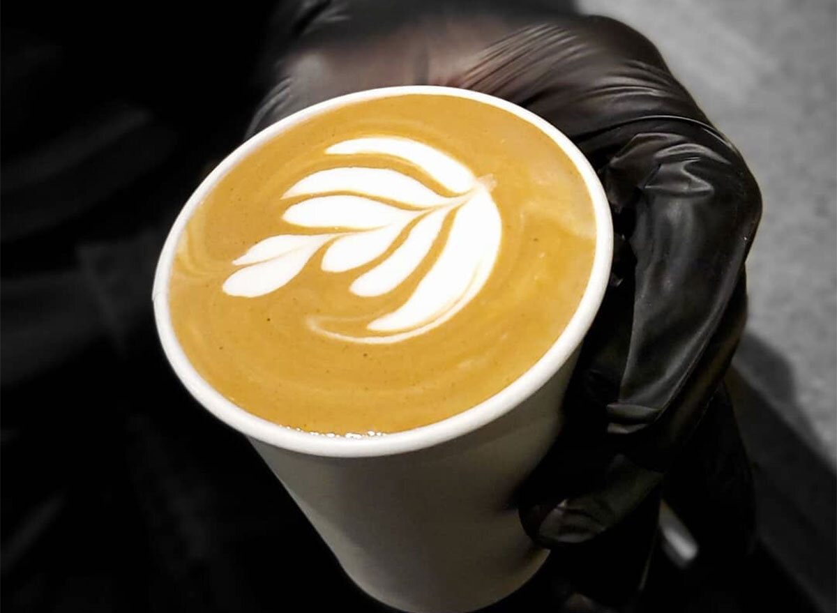 black gloved hands holding latte