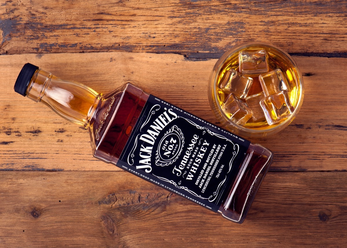 Jack Daniel's in a glass and bottle on a wooden table