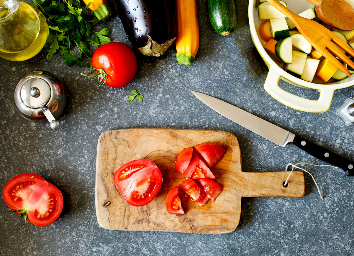 Low fodmap meal prep chopped tomatoes wooden cutting board zucchini in bowl