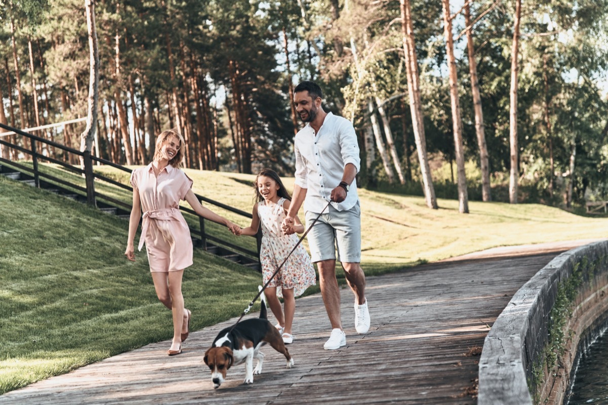 Family walking dog in park