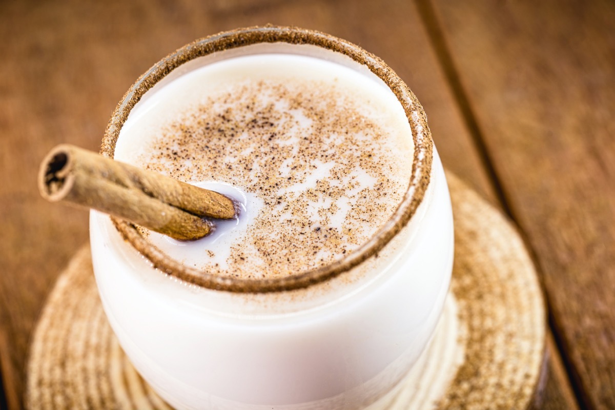 coquito or coconut eggnog in clear glass with cinnamon stick