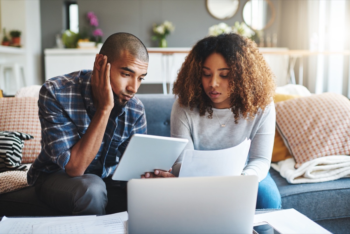 Cropped shot of a stressed young couple sitting together and using a laptop to go over their financial paperwork