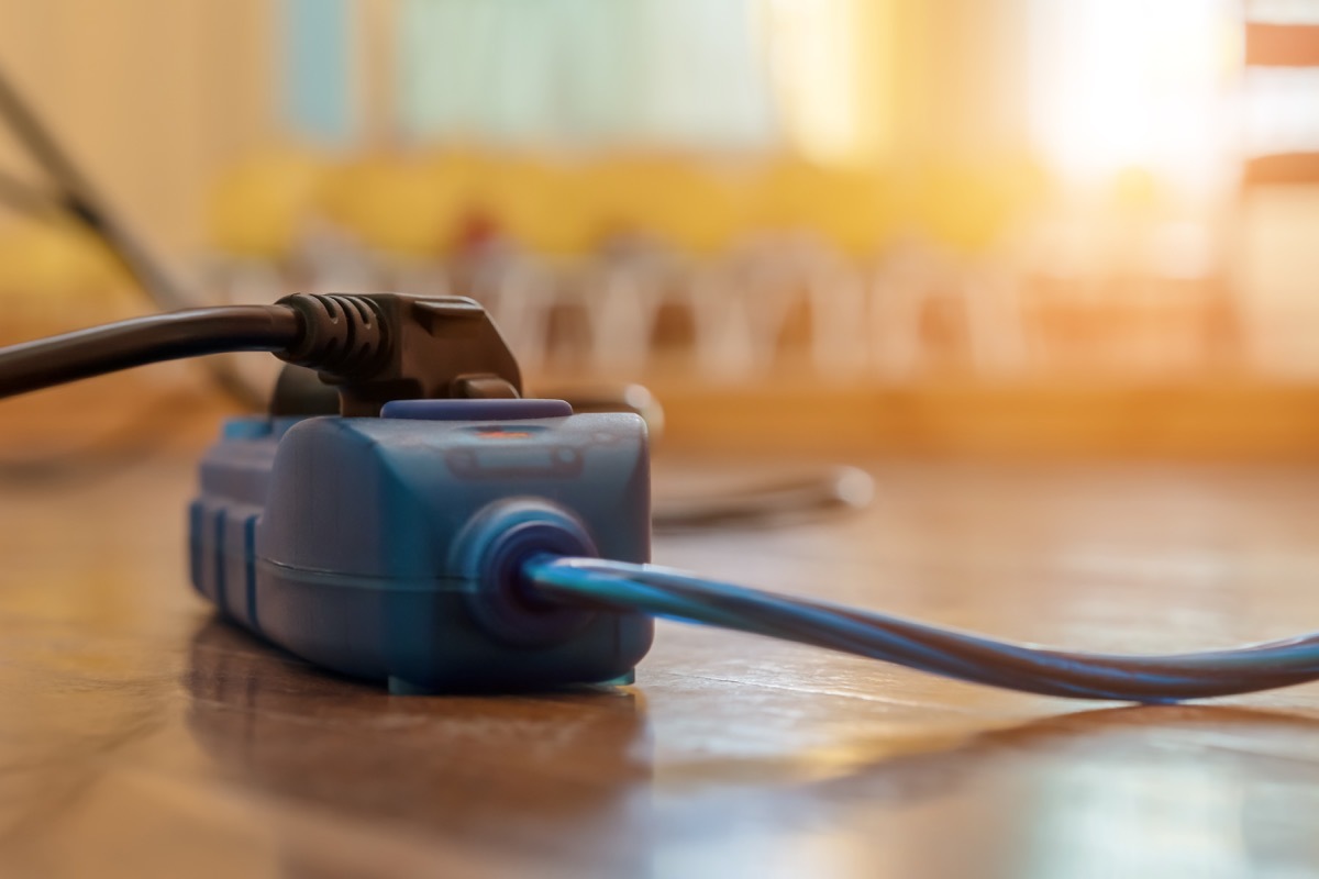 black cord plugged into blue extension cord