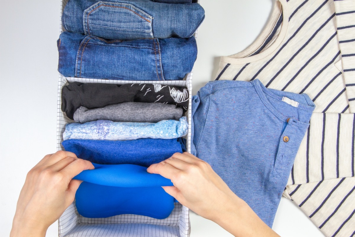 Woman hands tidying up clothes in basket