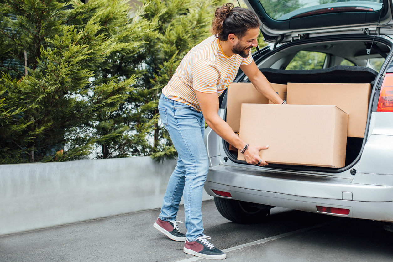 young man moving packing up car