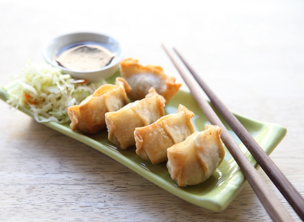 crab wonton on green plate with chopsticks