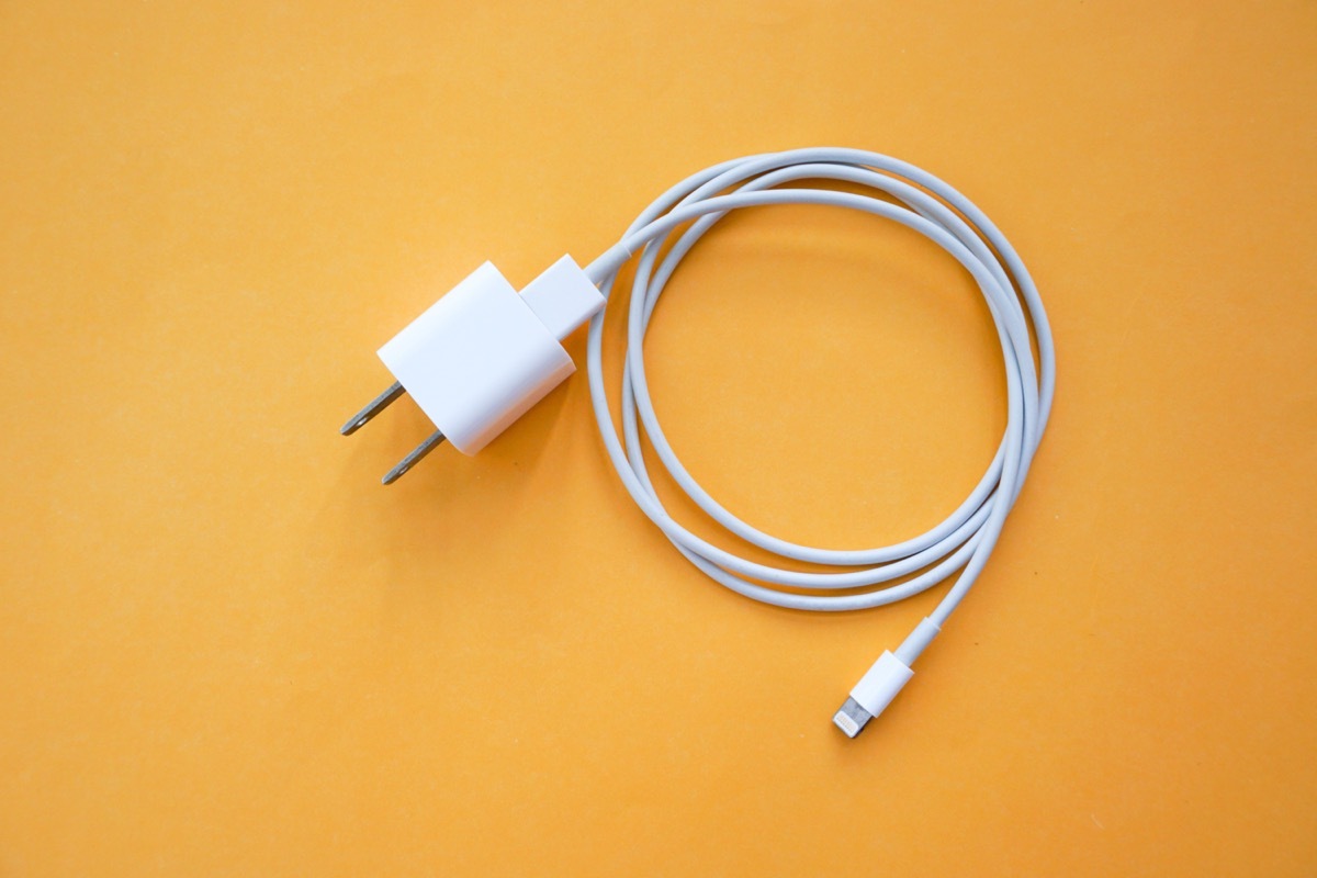 Mobile Phone Charger on Orange Background Top View