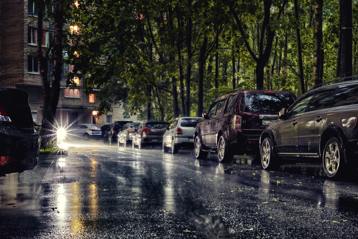 Generic city courtyard with parked cars under heavy rain. HDR street photo