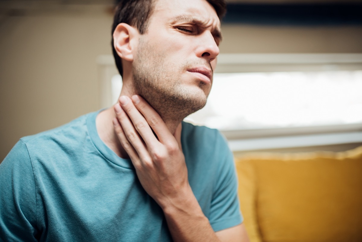 man touching his neck in pain