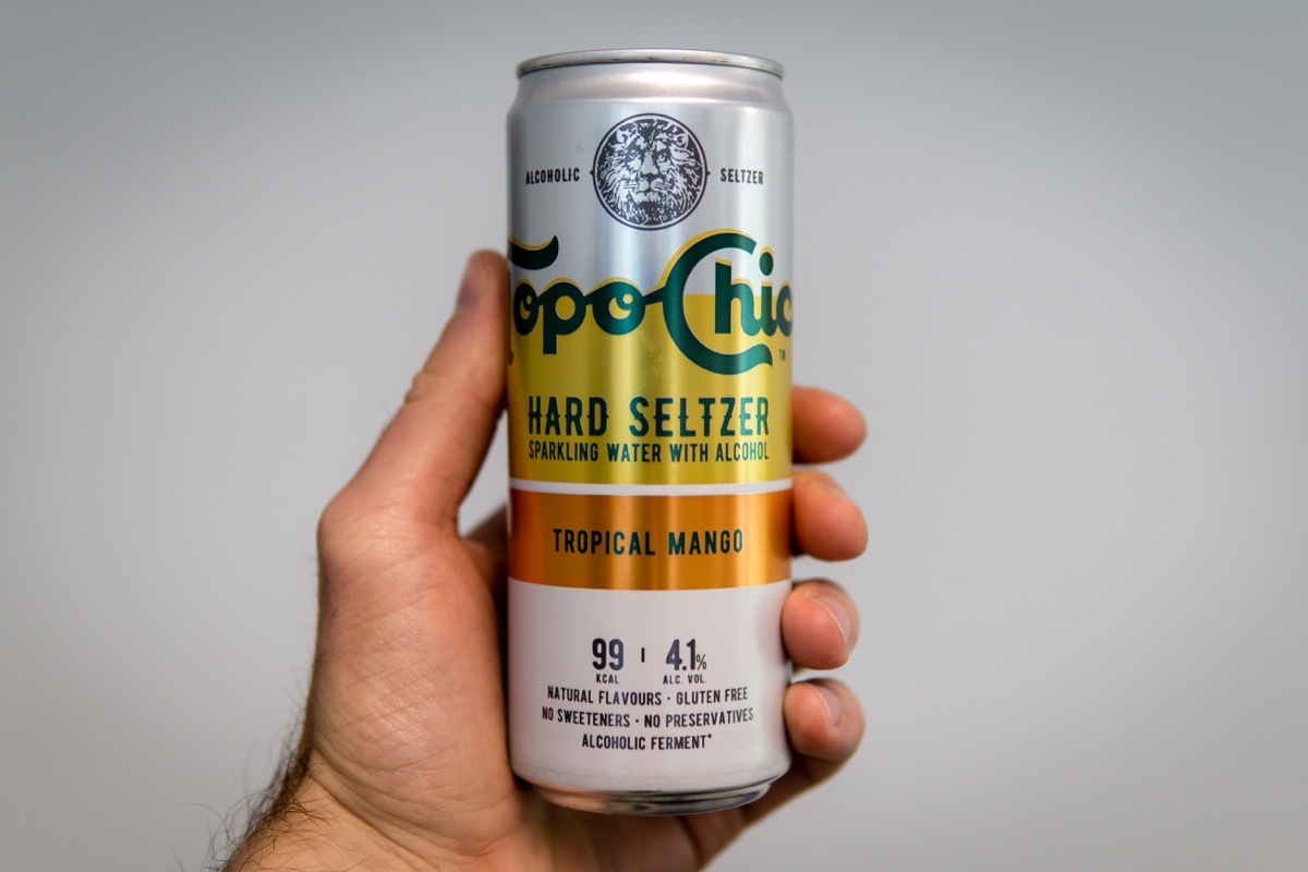 Munich, Germany, August 03rd 2021 : Ice cold Can of Topo Chico Tropical Mango holding in hand