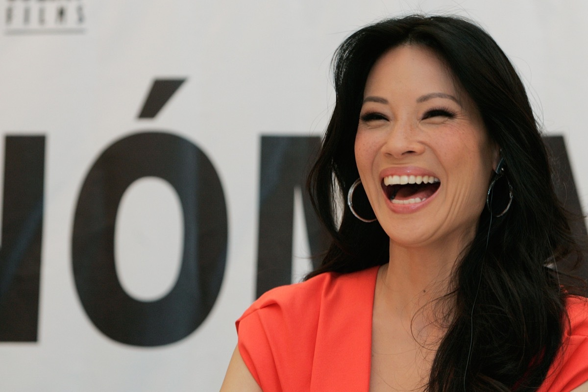 lucy liu wearing orange dress and laughing