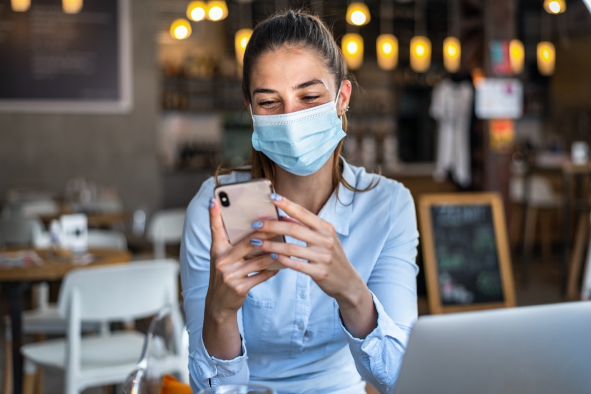 Woman, wearing mask while talking on a mobile phone.