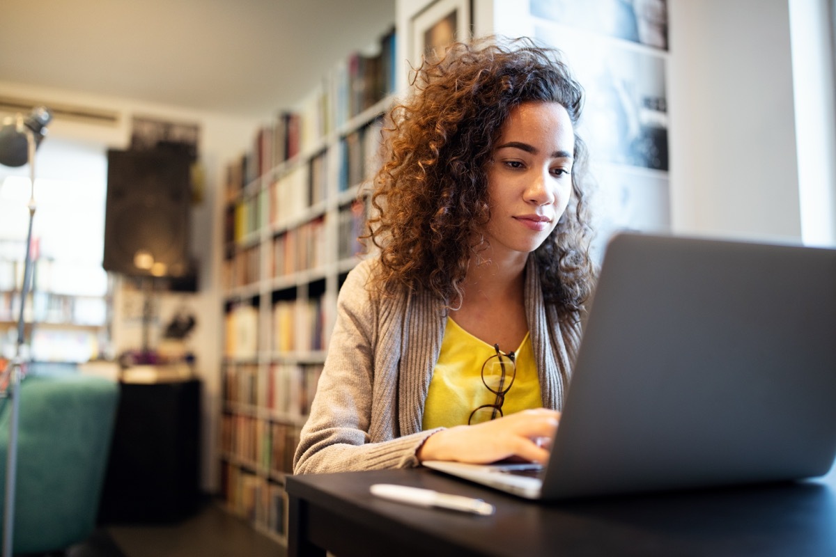 Young beautiful student girl working, learning in college library