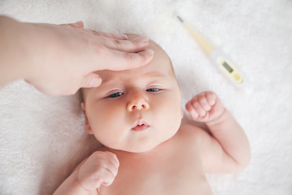 Mother Checks The Temperature Of A Sick Baby