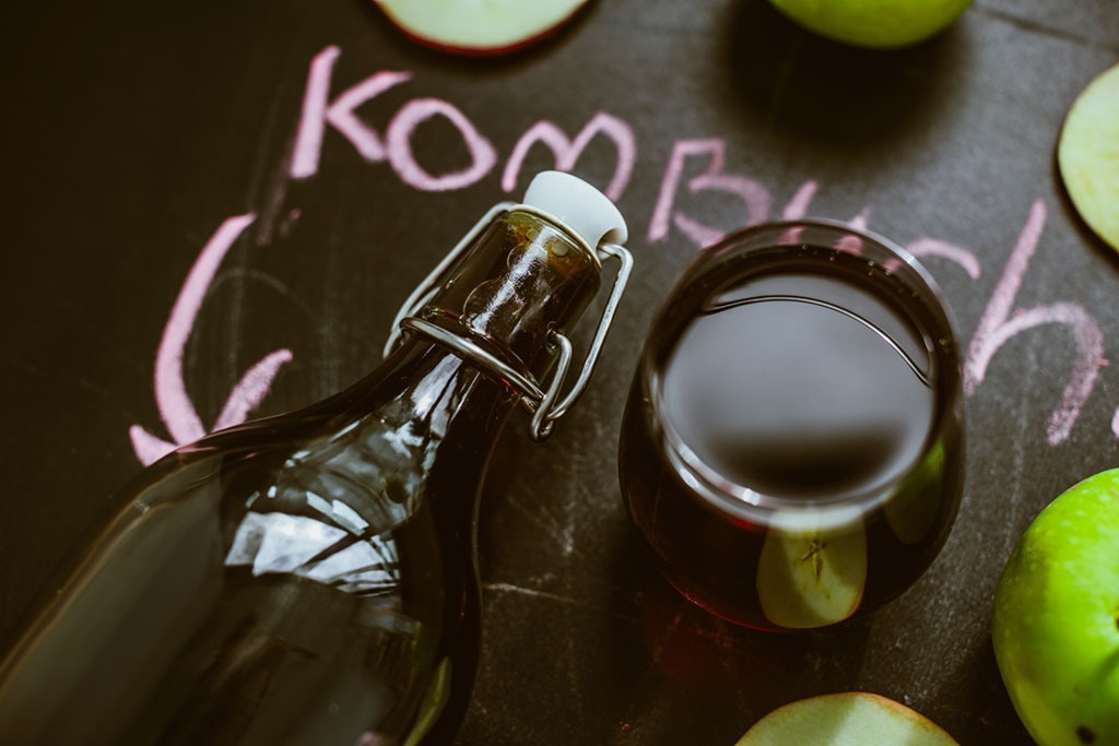 kombucha bottle next to glass