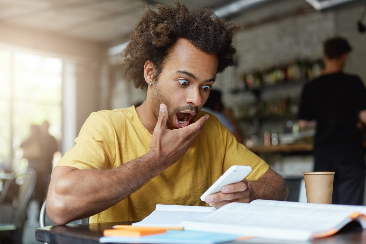 Man staring at phone surprised