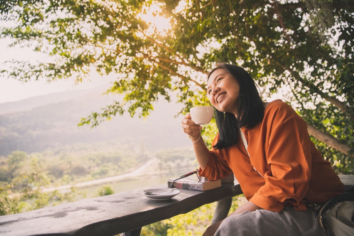 Woman drinking coffee in sunshine