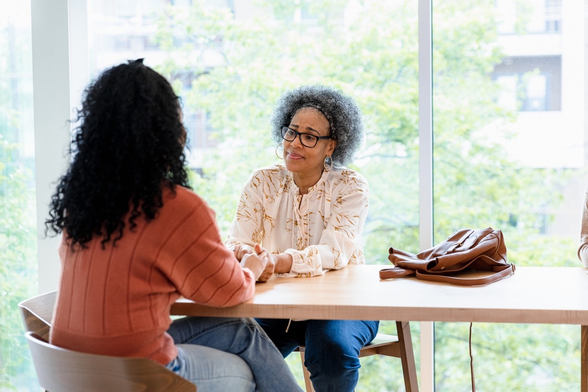 When they meet at the coffee shop, the senior adult mom consoles her unrecognizable adult daughter as she reaches out to hold her daughter's hands.