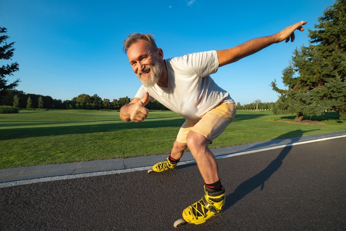 older white man rollerblading and giving the thumbs up