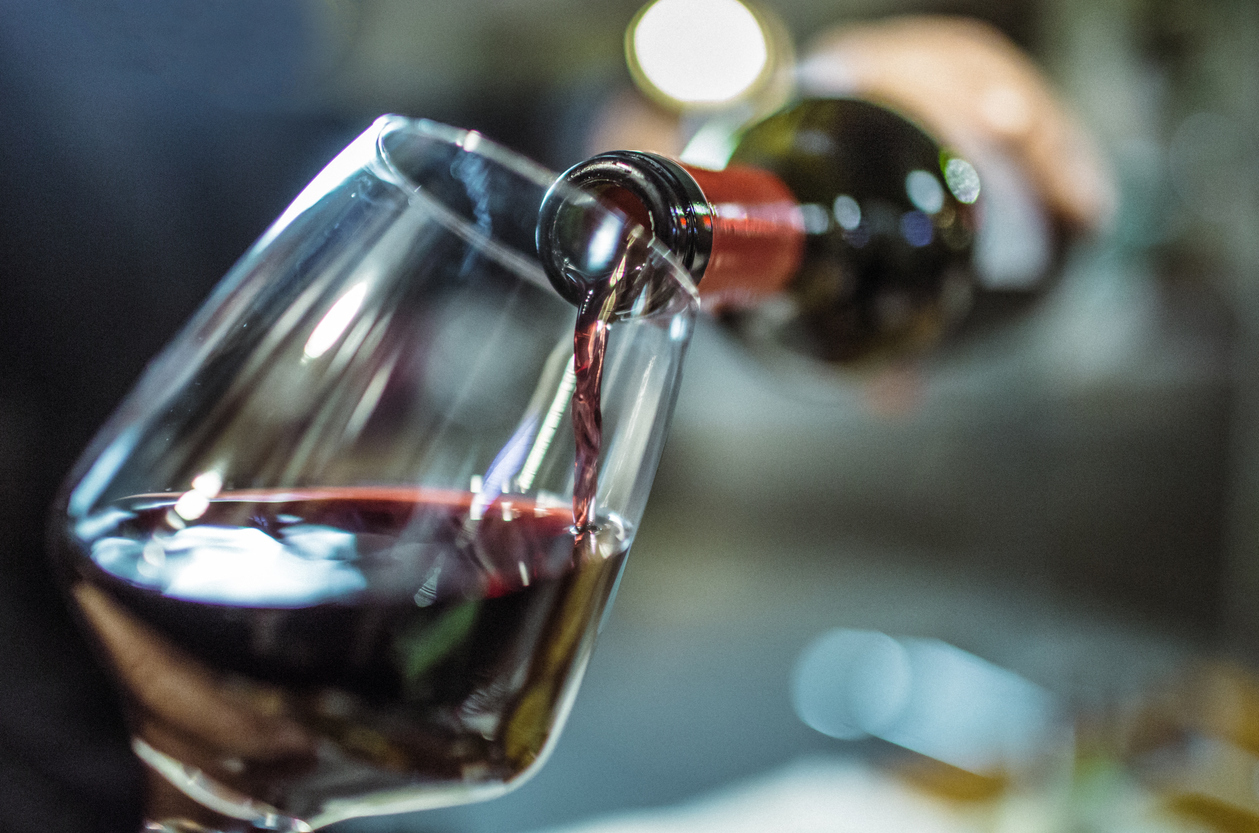 Red wine being poured into a glass.