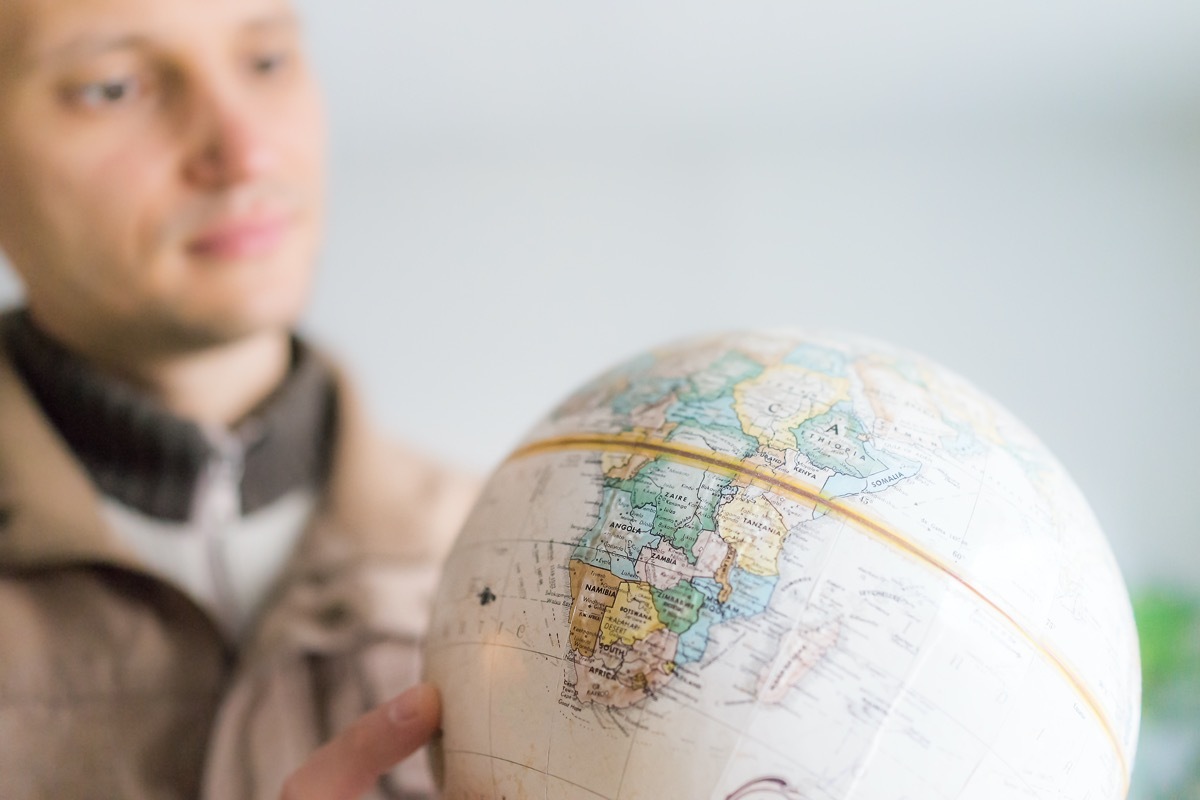 Man looking at globe with equator line