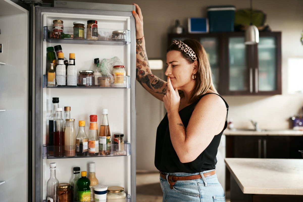 Shot of a young woman searching inside a refrigerator at home