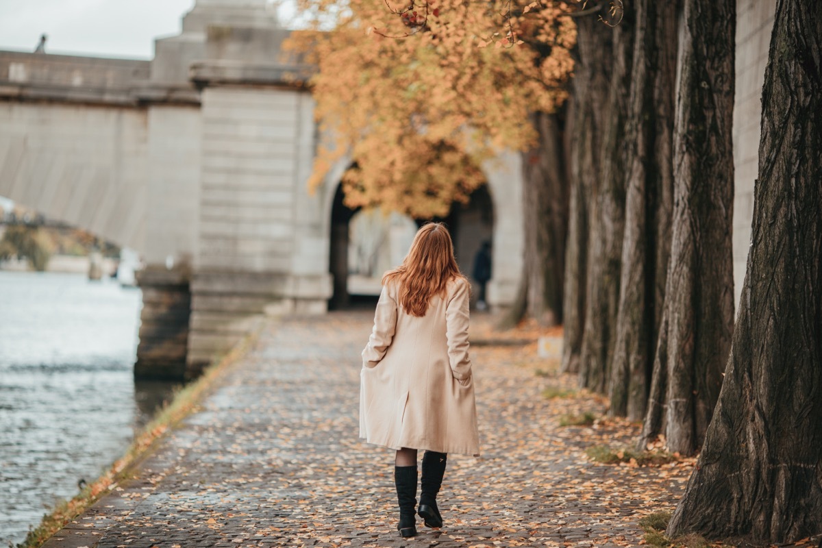 woman waling through town in fall