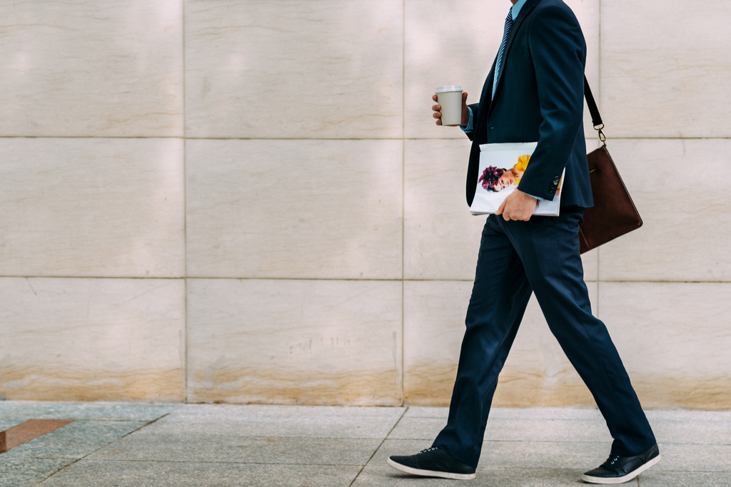 man holding a magazine and a to-go coffee - american culture