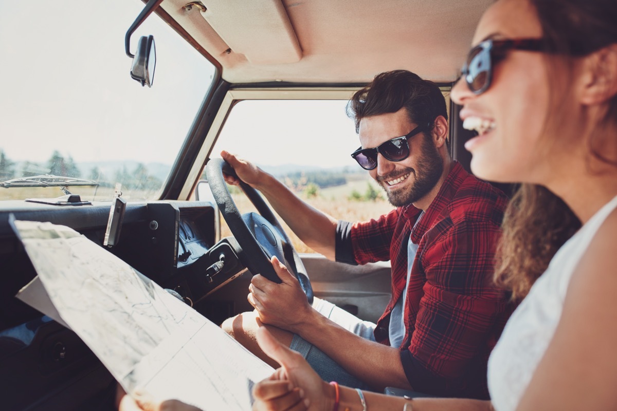 couple in car smiling while traveling