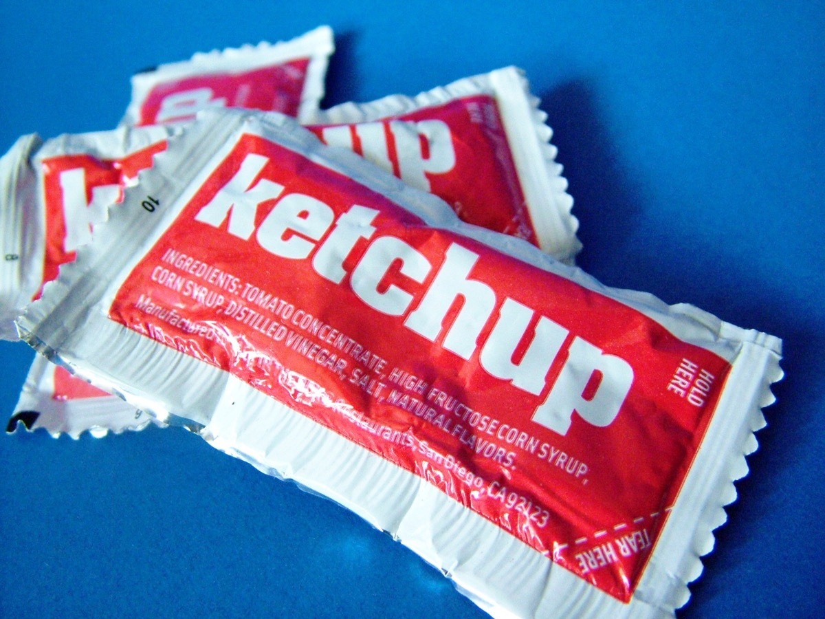 ketchup packets against a blue background